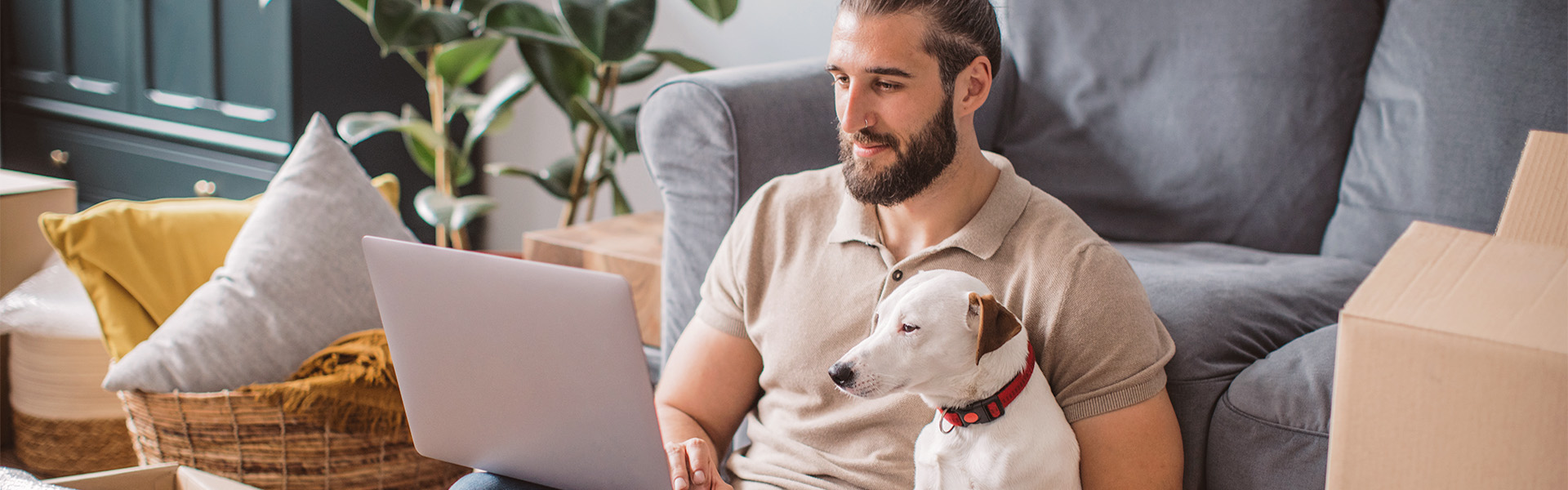 Man som tittar i datorn tillsammans med sin hund